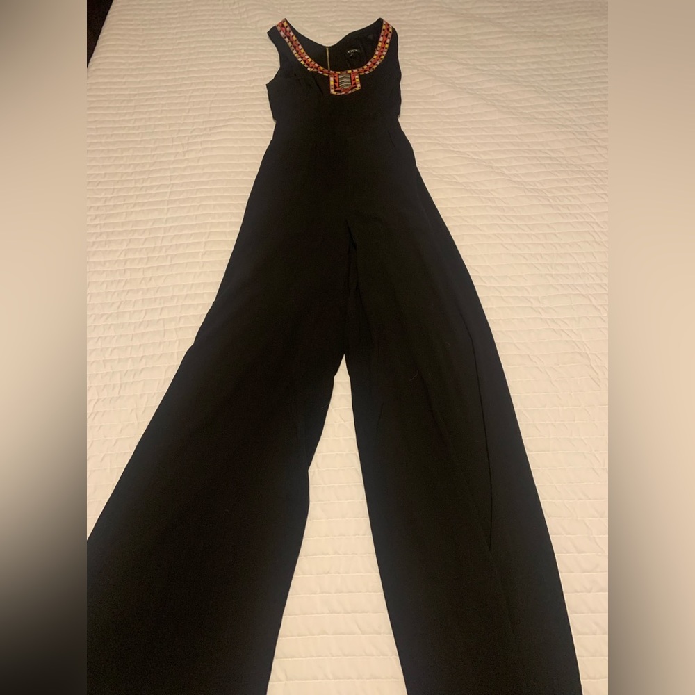 Black wide leg detailed jumpsuit with cutout detail on backside.